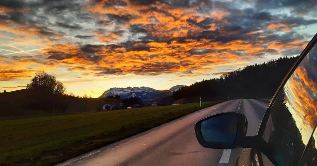 Tramonto su una strada di montagna, fotografato dall’auto